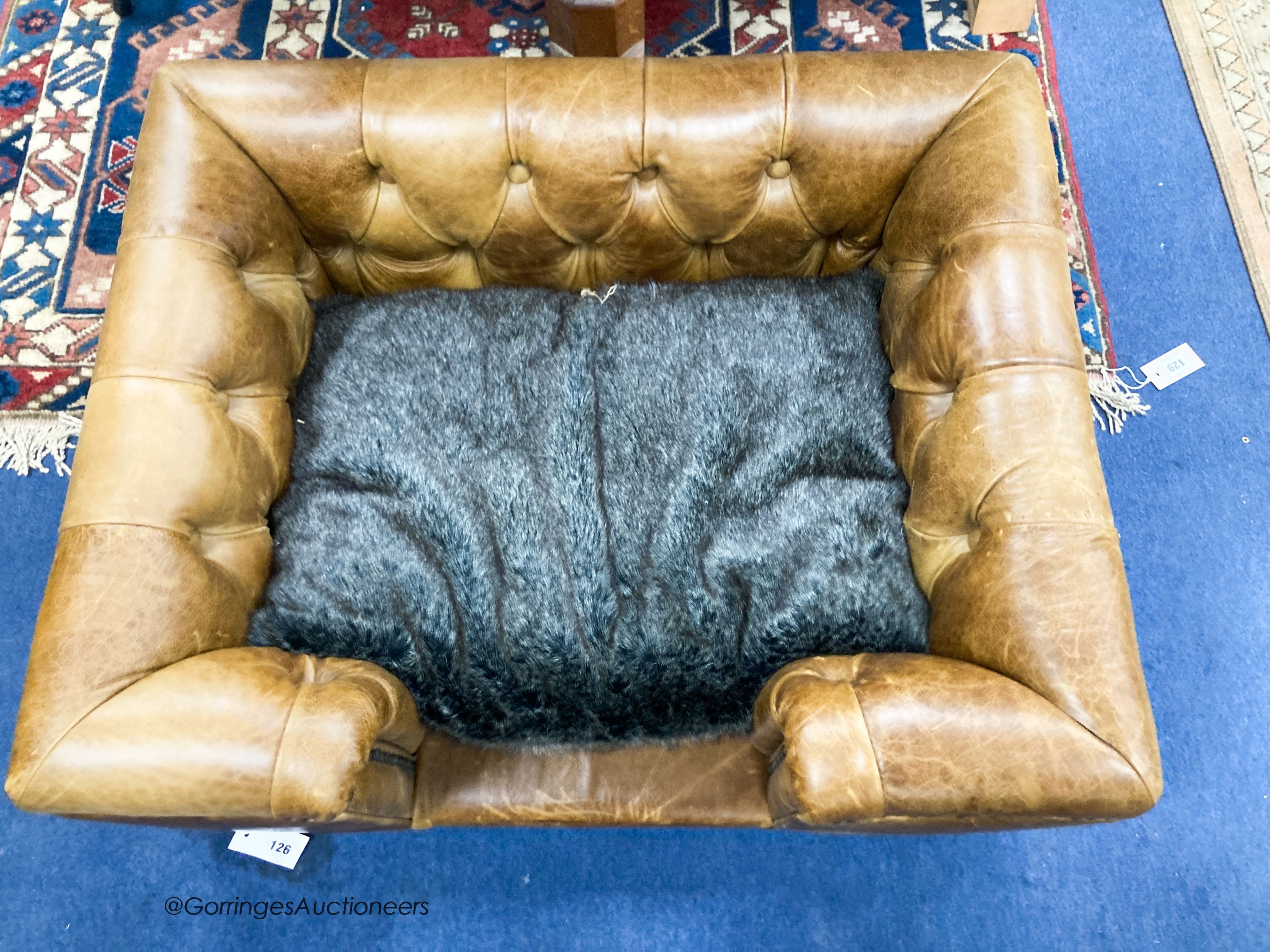 An Italian buttoned tan leather dog's bed with loose cushion, width 84cm, depth 68cm, height 36cm